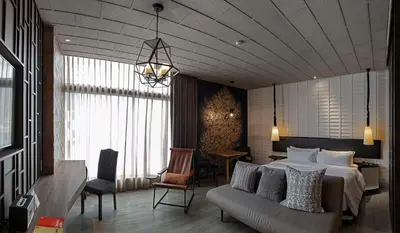 a bedroom with a bed and a couch and a table at Siam At Siam Design Hotel Bangkok in Bangkok
