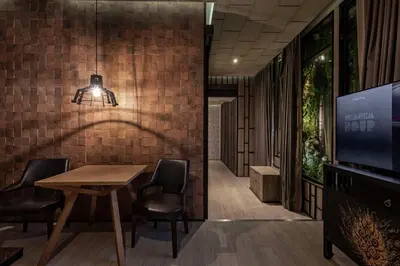 a dining room with a table and chairs and a tv at Siam At Siam Design Hotel Bangkok in Bangkok
