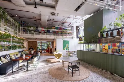 a restaurant with tables and chairs and plants at Siam At Siam Design Hotel Bangkok in Bangkok