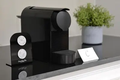 a black coffee maker on a counter with a plant at Centre Point Plus Hotel Silom - Newly Renovated in Bangkok