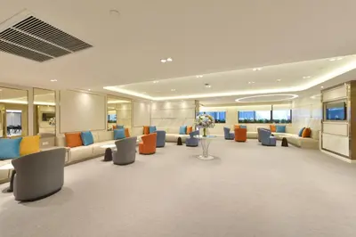 a lobby with orange and blue chairs and tables at Centre Point Plus Hotel Silom - Newly Renovated in Bangkok