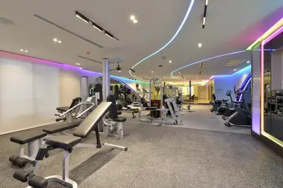 a gym with treadmills and machines in a room at Centre Point Plus Hotel Silom - Newly Renovated in Bangkok
