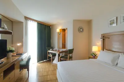 a hotel room with a bed and a desk and a table at AT EASE saladaeng by AETAS in Bangkok