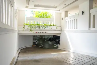 a hallway with a garage with cars parked under a balcony at AT EASE saladaeng by AETAS in Bangkok