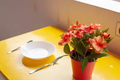 a vase of flowers on a table with a bowl at Clean Comfy Cozy easy to go Siam Paragon and Chatuchak Market in Bangkok