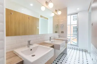 a bathroom with two sinks and a mirror at Atnest Hostel in Bangkok