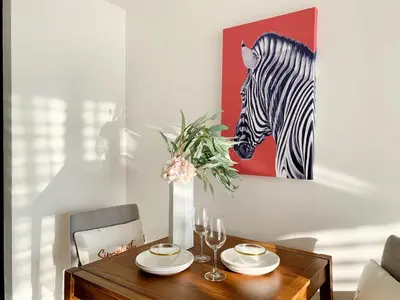 a dining room table with a painting of a zebra at Sukhumvit Asok Modern Suite in Bangkok