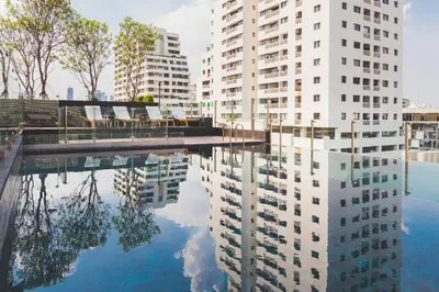 a reflection of buildings in a pool of water at Sukhumvit Asok Modern Suite in Bangkok