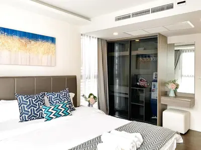 a bedroom with a large bed with blue and white pillows at Sukhumvit Asok Modern Suite in Bangkok