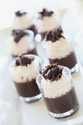 a group of chocolate desserts in glass cups on a table at Centara Life Government Complex Hotel & Convention Centre Chaeng Watthana in Bangkok