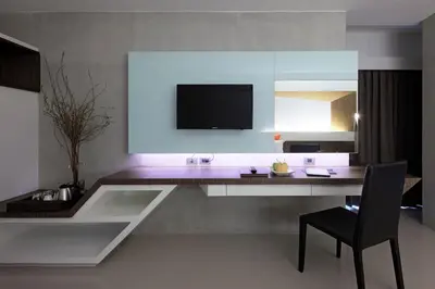 a room with a table and a chair and a television at Nine Forty One Hotel in Bangkok