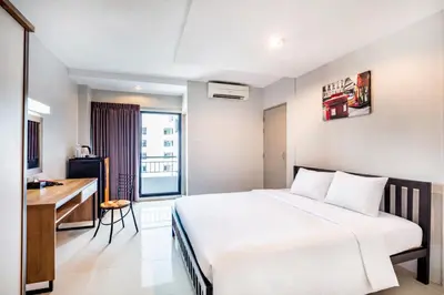 a hotel room with a bed and a desk at Aliz Hotel in Nonthaburi