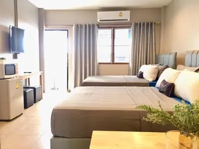 a hotel room with two beds and a table at R9 Bangkok in Bangkok