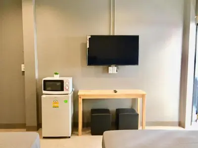 a room with a television and a table with a microwave at R9 Bangkok in Bangkok