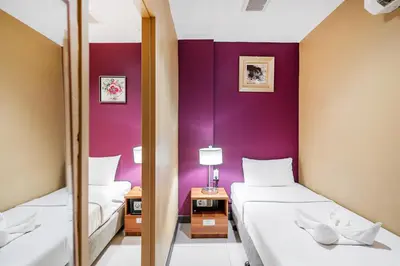 two beds in a room with purple walls at The Richy Place Guest House in Bangkok