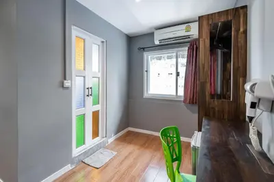 a room with a table and two windows at The Richy Place Guest House in Bangkok