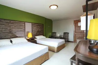 a hotel room with two beds and a desk at Rambuttri Village Plaza in Bangkok