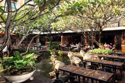 a restaurant with tables and people sitting at tables at Rambuttri Village Plaza in Bangkok