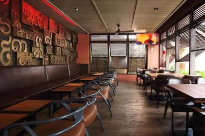 a dining room with tables and chairs in a restaurant at Rambuttri Village Plaza in Bangkok