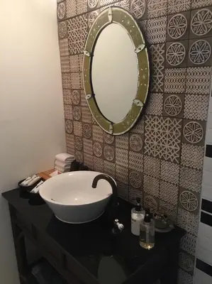 a bathroom with a sink and a mirror on a counter at Baan Chart in Bangkok