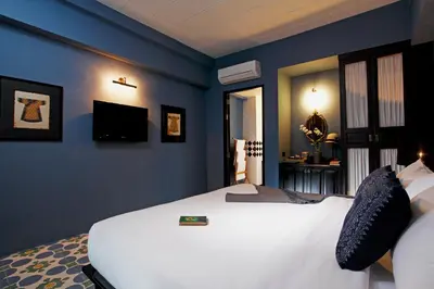 a bedroom with a white bed and blue walls at Baan Chart in Bangkok