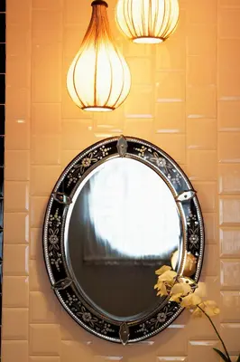 a mirror hanging on a wall with two lights at Baan Chart in Bangkok