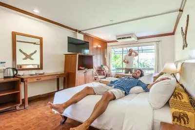 a man laying on a bed in a living room at Royal Ivory Sukhumvit Nana in Bangkok
