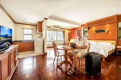 a man sitting at a table in a hotel room at Royal Ivory Sukhumvit Nana in Bangkok