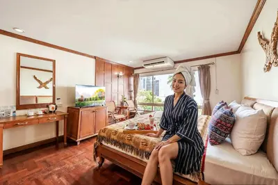a woman sitting on a bed in a room at Royal Ivory Sukhumvit Nana in Bangkok