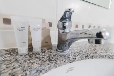a bathroom sink with a faucet and two bottles of soap at So good Hotel Bangkok in Bangkok