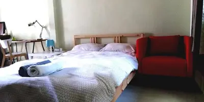 a bedroom with a bed and a red chair at NBH.@ Prannok in Bangkok