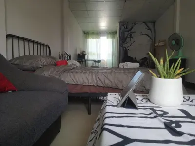 a bedroom with a bed and a laptop on a table at NBH.@ Prannok in Bangkok
