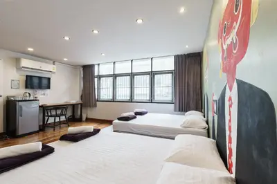 a room with three beds and a stop sign on the wall at 99 Hostel Khaosan in Bangkok