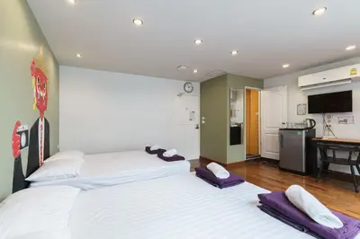 two beds in a room with a kitchen at 99 Hostel Khaosan in Bangkok