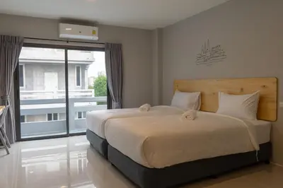 a bedroom with a large bed and a large window at Fine Bed Hotel in Nonthaburi