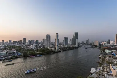 a river with a city in the background at Chatrium Hotel Riverside Bangkok in Bangkok