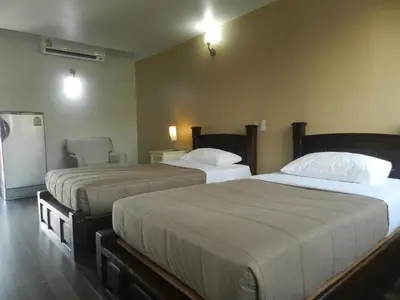 a bedroom with two beds and a refrigerator at City Residence Rama 6 in Bangkok