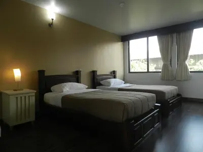 two beds in a hotel room with a window at City Residence Rama 6 in Bangkok