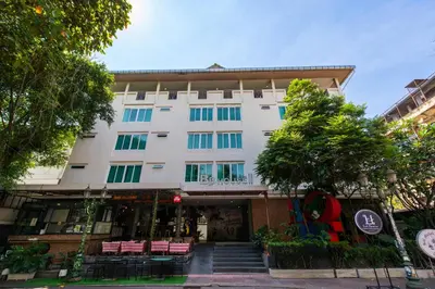 a building with chairs and trees in front of it at BB House Rambuttri2 บีบี เฮ้าส์ รามบุตรี2 in Bangkok