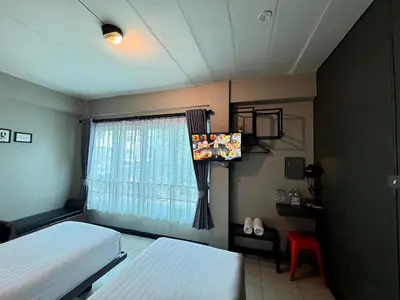 a bedroom with two beds and a window at BB House Rambuttri2 บีบี เฮ้าส์ รามบุตรี2 in Bangkok