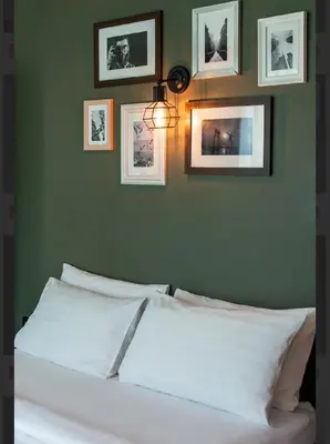 a bedroom with a white bed with pictures on the wall at BB House Rambuttri2 บีบี เฮ้าส์ รามบุตรี2 in Bangkok