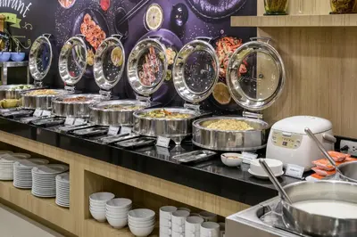 a buffet line with many pans of food at Adelphi Grande Sukhumvit in Bangkok
