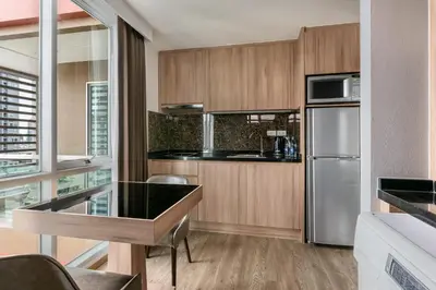 a kitchen with wooden cabinets and stainless steel appliances at Adelphi Grande Sukhumvit in Bangkok
