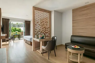 a hotel room with a bed and a couch at Adelphi Grande Sukhumvit in Bangkok