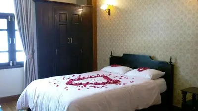 a bedroom with a bed with red roses on it at The Royal ThaTien Village in Bangkok