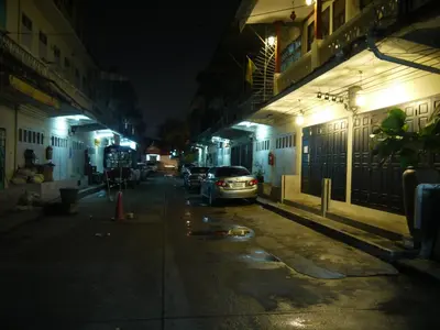 a car parked on the side of a street at night at The Royal ThaTien Village in Bangkok