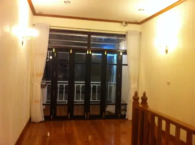 a living room with a door to a balcony at The Royal ThaTien Village in Bangkok