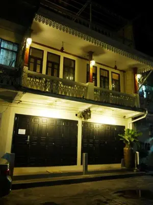 a white house with a balcony and two garage doors at The Royal ThaTien Village in Bangkok