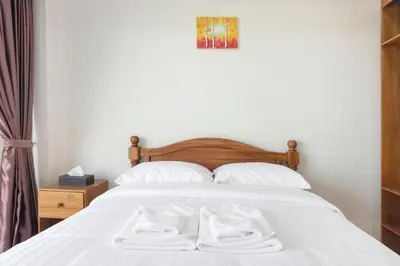 a bedroom with a bed with two white towels on it at Royale 8 Ville Guest House in Bangkok