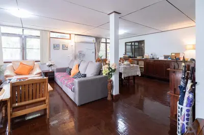 a living room with a couch and a kitchen at Dunah's Garden Home in Bangkok